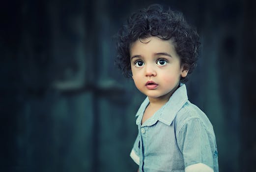 Charming portrait of a young boy with curly hair and striking eyes.