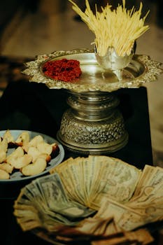 Traditional Nepalese offering with currency, sweets, and silver plates in Butwal.